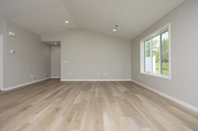 empty room with light wood-type flooring and lofted ceiling