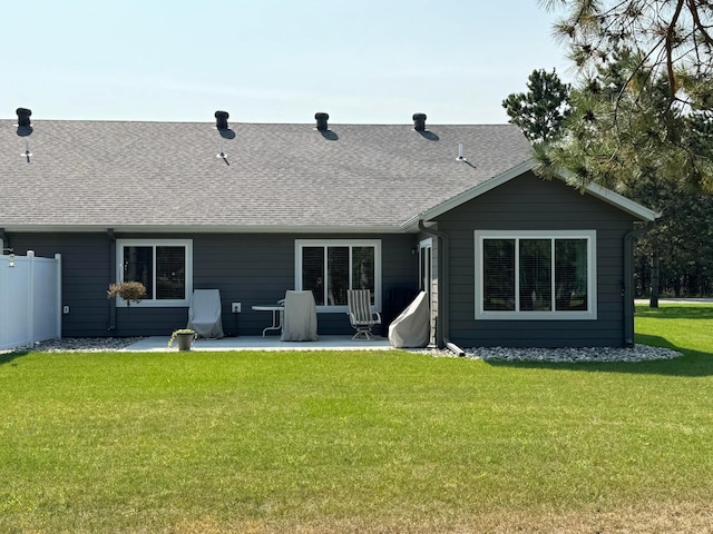 rear view of house featuring a lawn and a patio