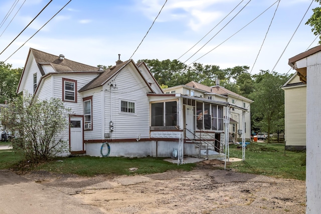 rear view of property with a yard and a sunroom