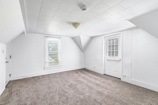 bonus room with vaulted ceiling and carpet