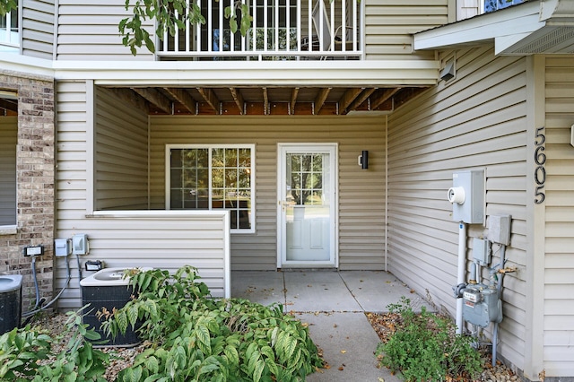 entrance to property featuring central AC unit and a patio