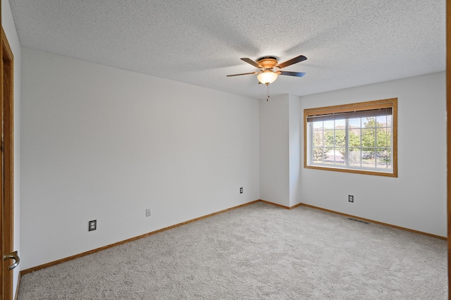 spare room with ceiling fan, carpet, and a textured ceiling