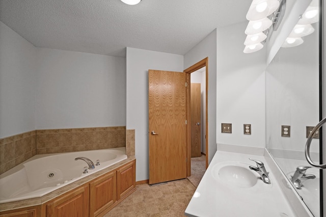 bathroom featuring vanity, a textured ceiling, and a bath