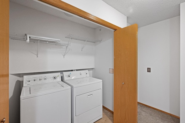 laundry room featuring a textured ceiling and washer and clothes dryer