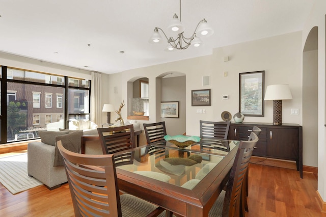 dining space featuring hardwood / wood-style flooring and a notable chandelier