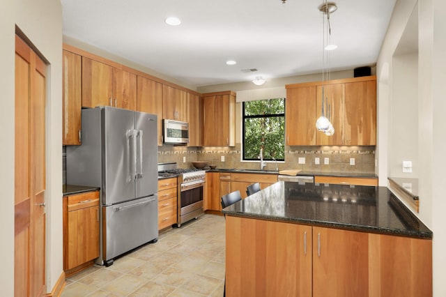 kitchen with backsplash, dark stone counters, high end appliances, sink, and hanging light fixtures