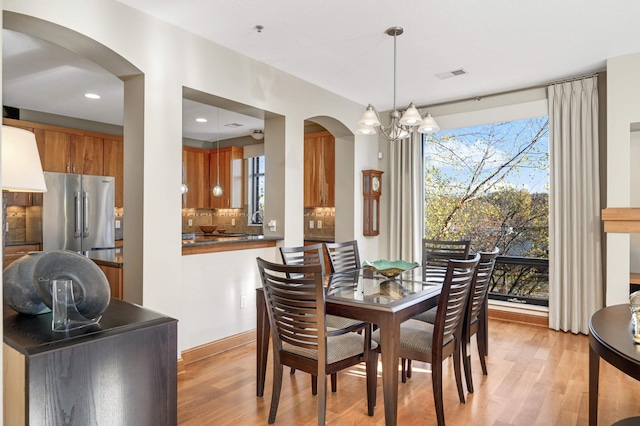 dining area featuring a chandelier, light hardwood / wood-style floors, and a healthy amount of sunlight