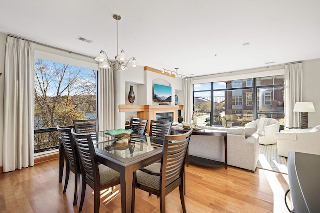 dining area with a chandelier, light wood-type flooring, and plenty of natural light