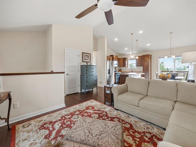 living room with ceiling fan, vaulted ceiling, and dark hardwood / wood-style floors