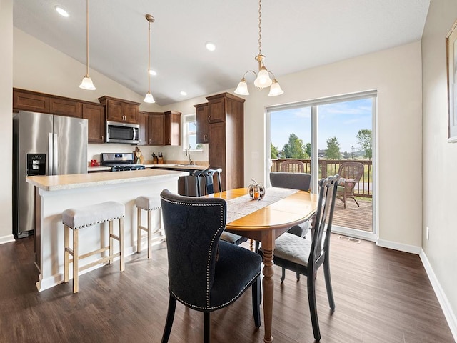 dining space with an inviting chandelier, sink, dark wood-type flooring, and vaulted ceiling