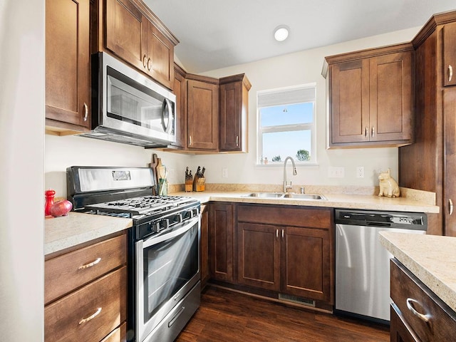 kitchen with sink, stainless steel appliances, and dark hardwood / wood-style flooring