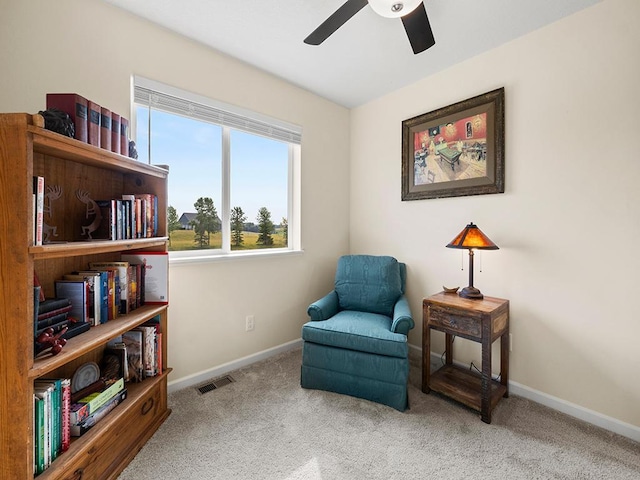 living area featuring carpet floors and ceiling fan