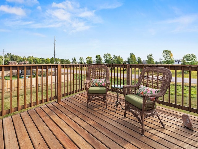 wooden deck featuring a lawn