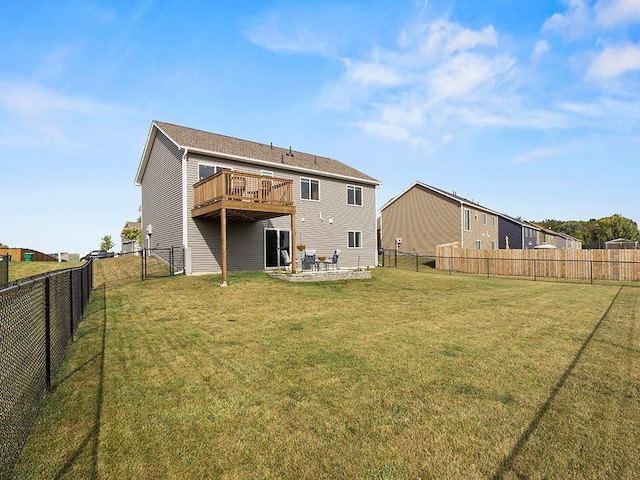 rear view of property featuring a deck, a yard, and a patio area