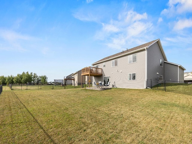 rear view of property with a yard and a deck