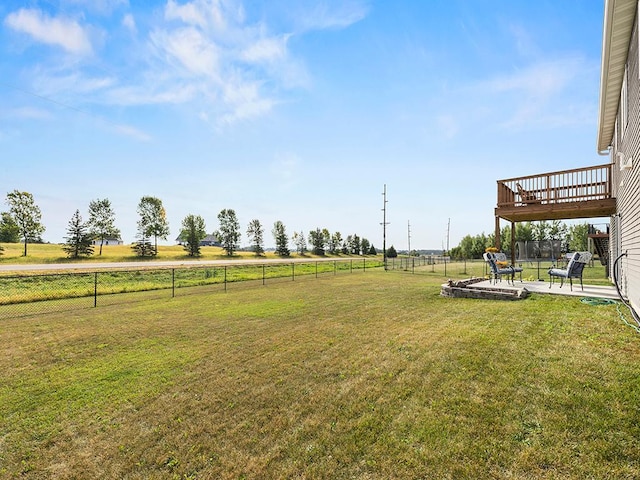 view of yard featuring a rural view, a patio, and a wooden deck