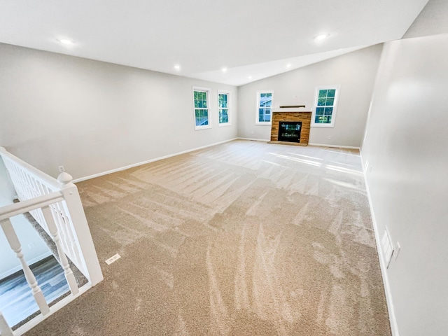 327 Oakwood Dr, Shoreview, MN 55126 - unfurnished living room with carpet floors, a glass covered fireplace, lofted ceiling, baseboards, and recessed lighting