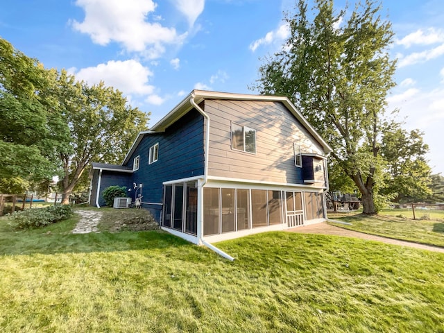 rear view of property with a sunroom and a yard