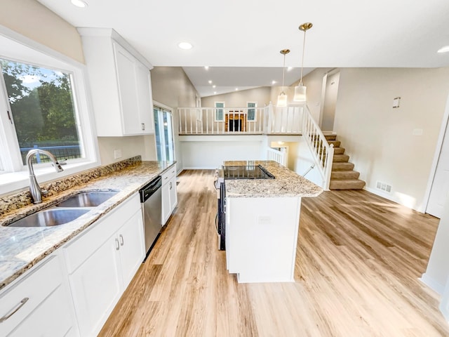 kitchen with dishwasher, sink, light stone countertops, a kitchen island, and white cabinetry