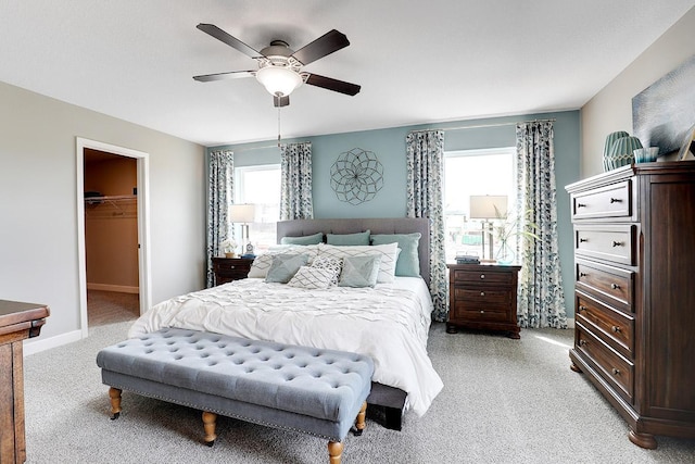 carpeted bedroom with ceiling fan, a closet, and a spacious closet