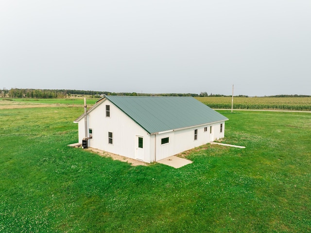 exterior space featuring central air condition unit, a yard, and a rural view