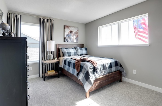 bedroom featuring light carpet and multiple windows