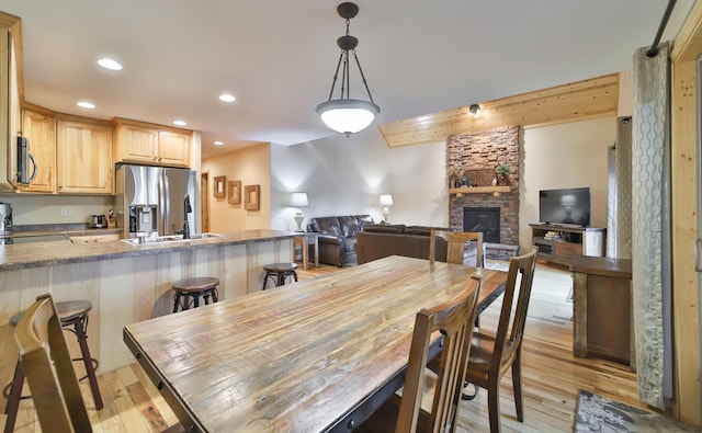 dining area with light hardwood / wood-style floors, a fireplace, and sink