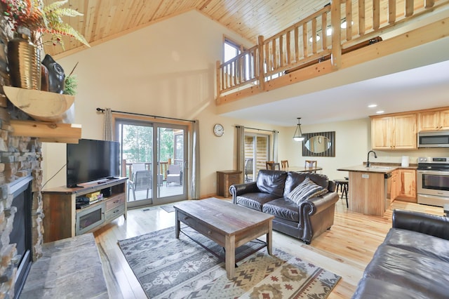 living room with wooden ceiling, a fireplace, light hardwood / wood-style flooring, and high vaulted ceiling