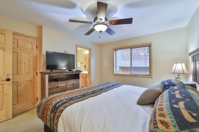 carpeted bedroom with ceiling fan and ensuite bath