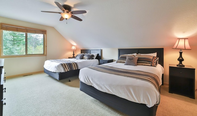 bedroom with a textured ceiling, lofted ceiling, carpet flooring, and ceiling fan