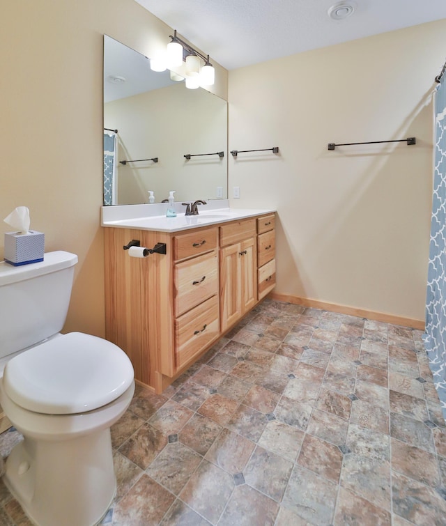 bathroom featuring walk in shower, vanity, and toilet