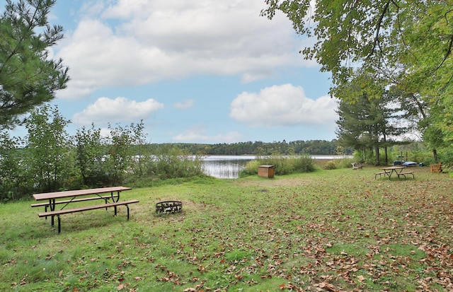 view of home's community with a water view and a yard