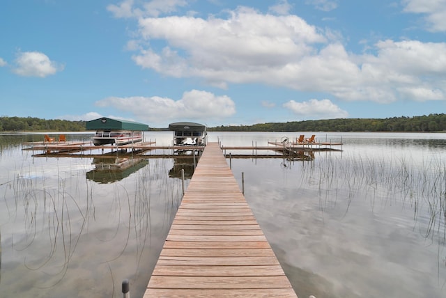 6334 Wilderness Rd Unit 31, Pequot Lakes, MN 56472 - view of dock featuring boat lift, a wooded view, and a water view