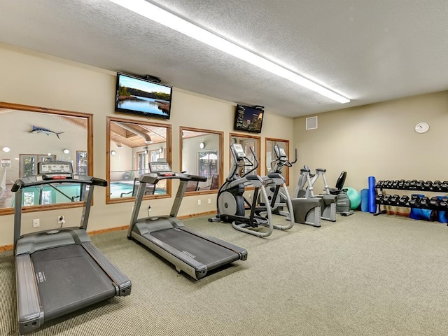 workout area with a textured ceiling and carpet floors