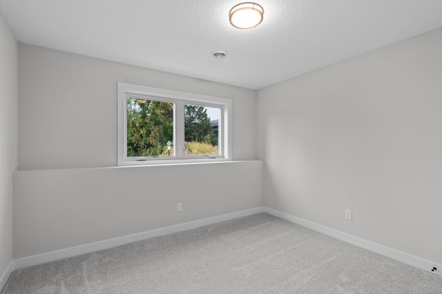 carpeted spare room featuring a textured ceiling