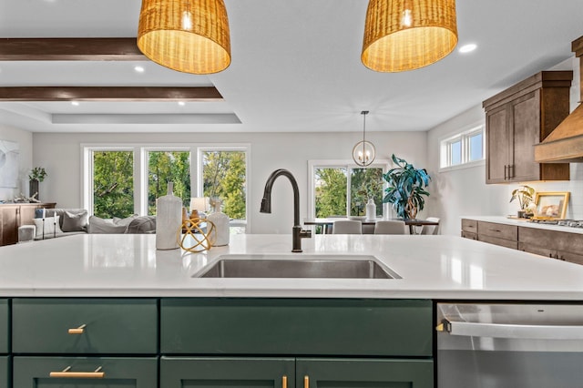 kitchen featuring green cabinets, a tray ceiling, dishwasher, and sink