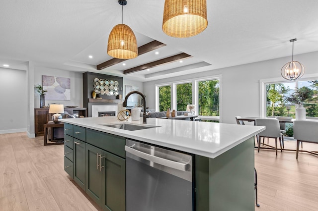 kitchen with decorative light fixtures, dishwasher, a kitchen island with sink, and light hardwood / wood-style flooring