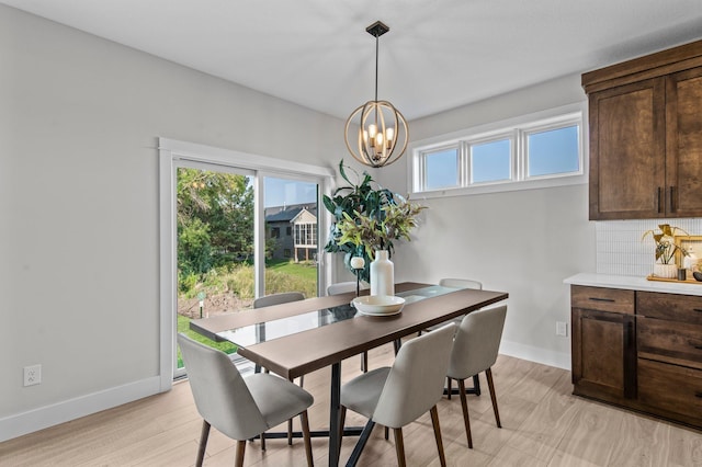 dining area featuring light wood-type flooring and a chandelier