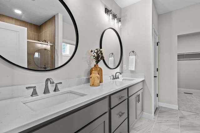 bathroom with vanity, a textured ceiling, and a shower