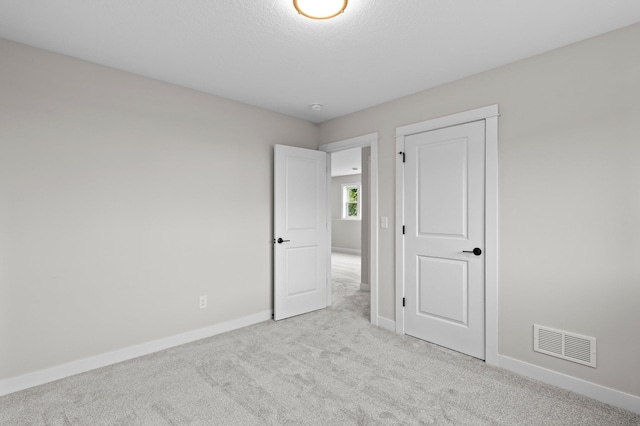 unfurnished bedroom featuring light carpet