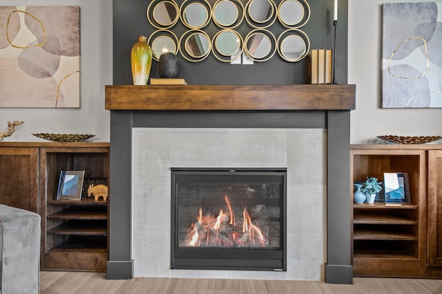 room details with wood finished floors and a tile fireplace