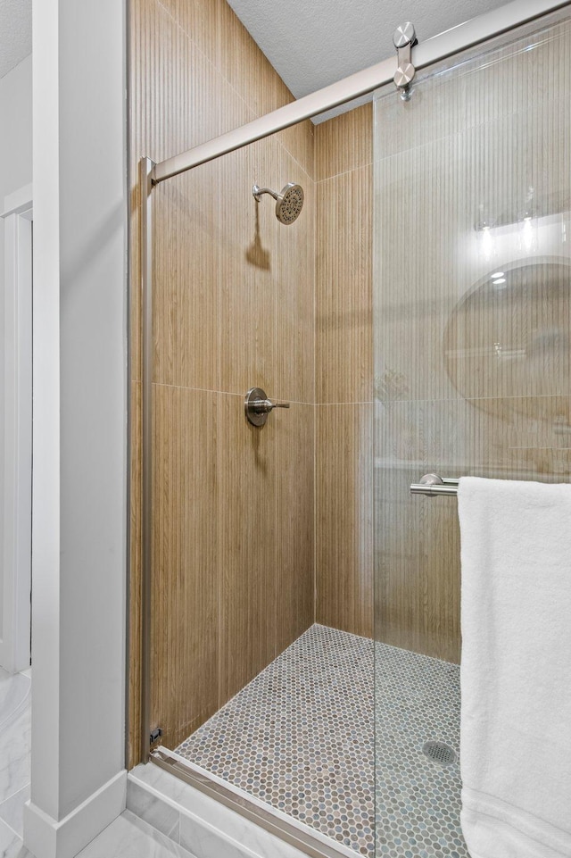 bathroom with a textured ceiling and a shower stall