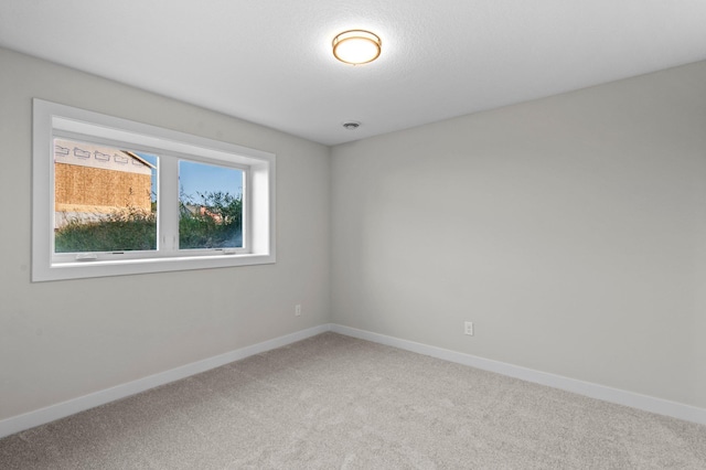 unfurnished room featuring carpet and baseboards