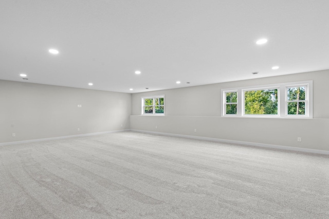 unfurnished room featuring recessed lighting, light colored carpet, and baseboards