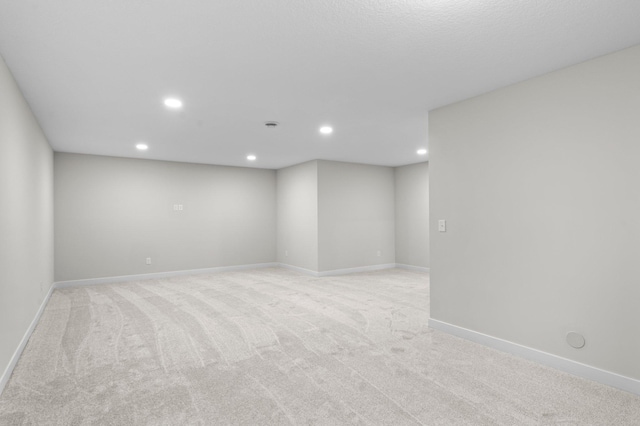 unfurnished room with recessed lighting, baseboards, and light colored carpet