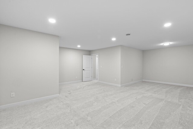 spare room featuring light carpet, baseboards, and recessed lighting