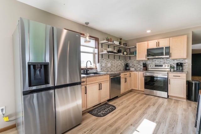 kitchen with a sink, open shelves, light brown cabinets, and stainless steel appliances