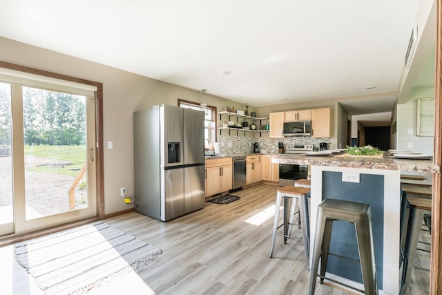 kitchen with light brown cabinets, open shelves, stainless steel appliances, light countertops, and decorative backsplash