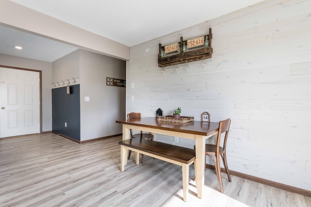 dining space with baseboards and light wood-style floors