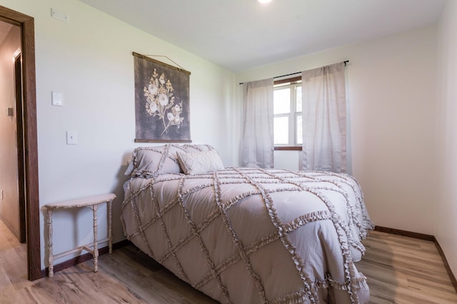 bedroom featuring baseboards and wood finished floors